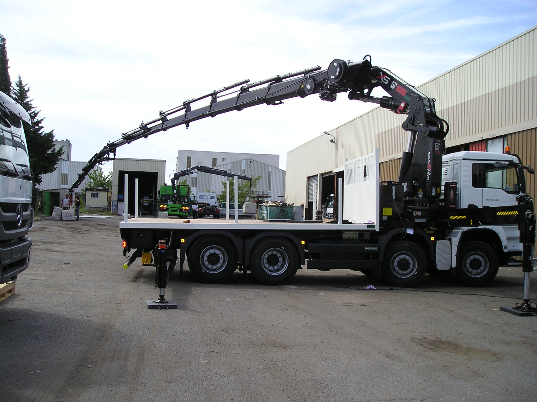 Grue HIAB 1055 E8 HIPRO + JIB 175x5 sur porteur 32 T équipé d'un plateau nu de longueur utile 5500 mm.