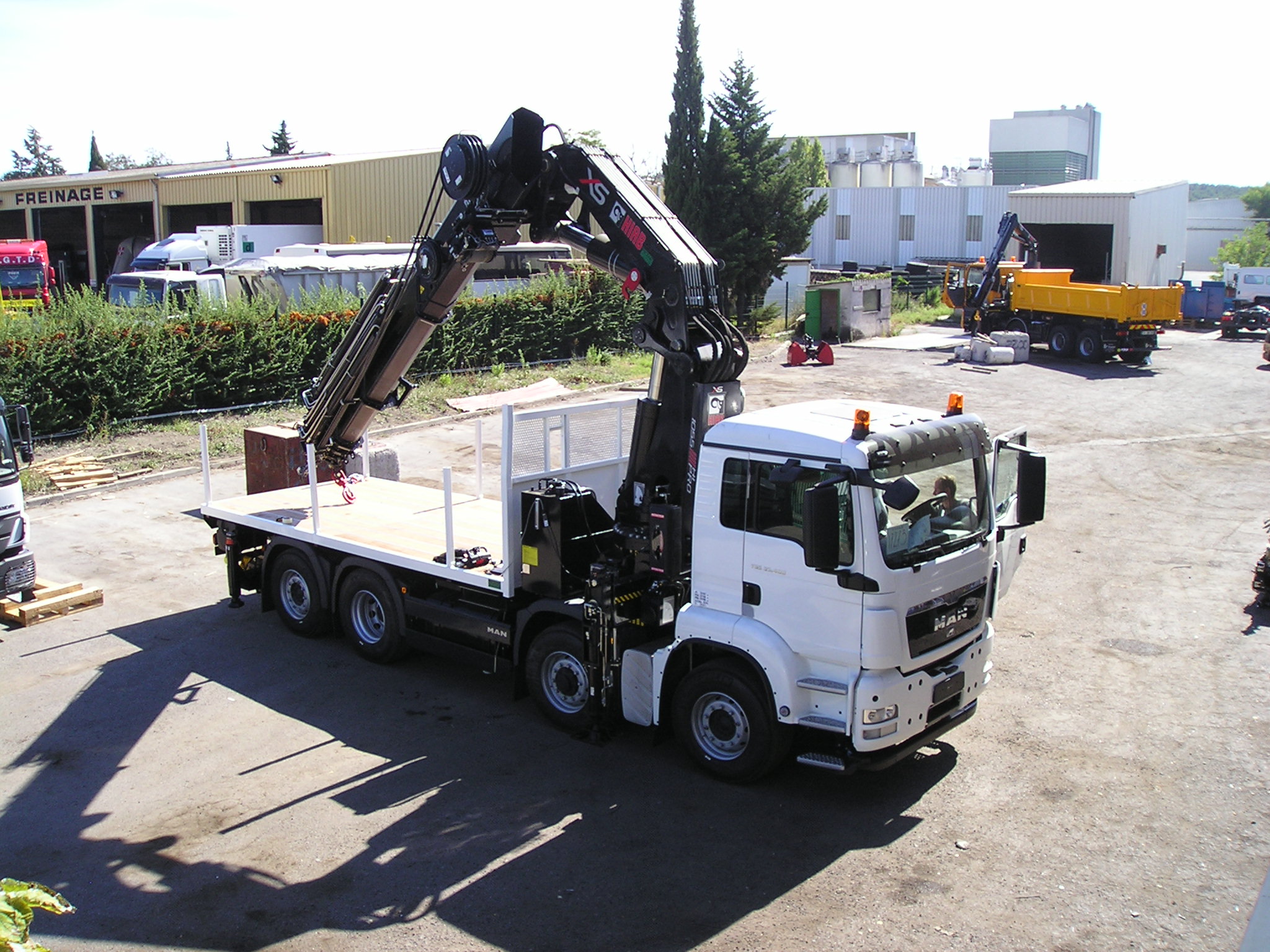 Grue HIAB 1055 E8 HIPRO + JIB 175x5 sur porteur 32 T équipé d'un plateau nu de longueur utile 5500 mm.